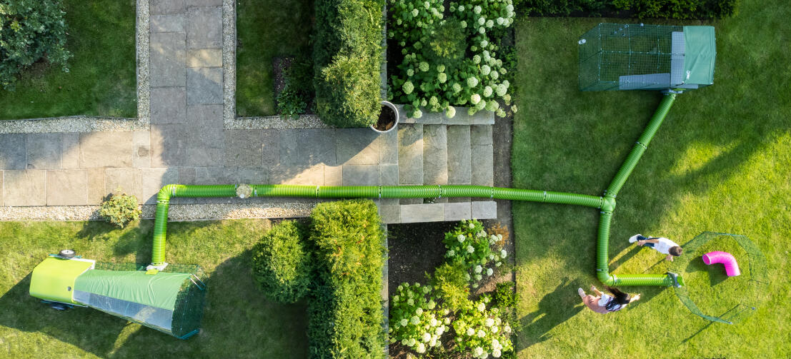 Drönarbild av Zippi springbana, lekhage och tunnelsystem i en trädgård.