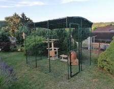 En inbyggd springgård i trädgården som är avsedd för en katt med katträd, leksaker och tillbehör