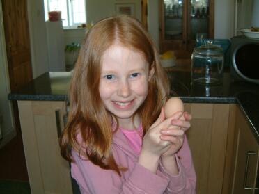 Emily håller stolt vårt första ägg. Vi tror att det kom från Dorothy.