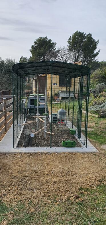 Hönshus installerat på en betongkant för enkel gräsklippning utan att skada trådnätet