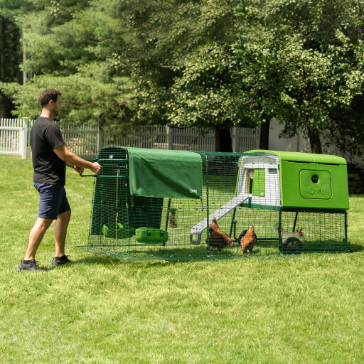 Man flyttar Eglu Cube portabelt hönshus i plast