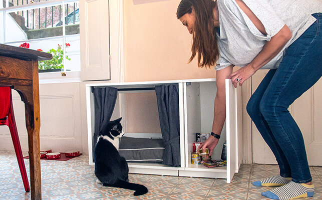 Kattsängen Maya Nook med garderoben öppen och en katt tittar in